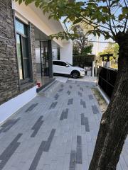 Driveway leading to a modern house with a parked car