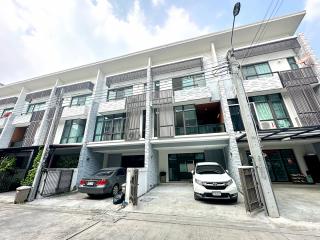 Modern multi-story residential townhouses with parking spaces