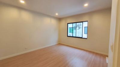 Spacious bedroom with hardwood floors and large window