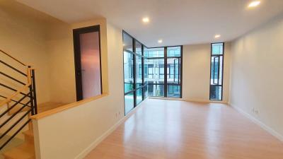 Spacious and well-lit living room with large windows and wooden flooring