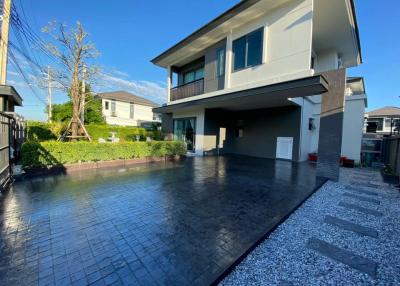 Modern two-story house with a spacious carport and well-maintained front yard