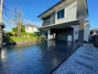 Modern two-story house with a spacious carport and well-maintained front yard