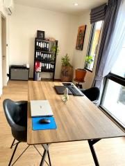 Modern home office with large wooden desk and comfortable chairs