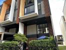 Modern multi-story residential building with balconies and exterior wood paneling