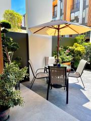Spacious and well-furnished outdoor patio area with plants and sunlight