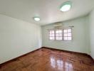 Spacious bedroom with parquet flooring, bright windows, and air conditioning unit