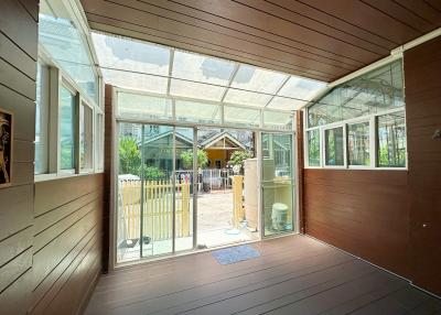 Spacious sunroom with transparent ceiling and wooden floors