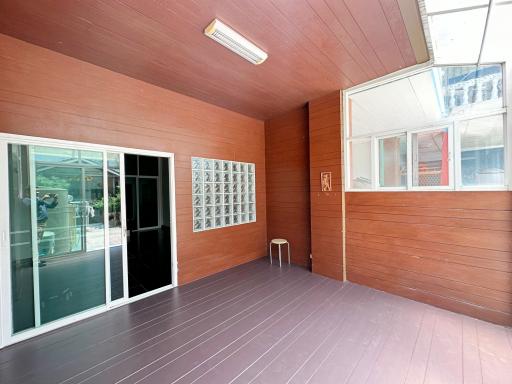 Spacious covered patio area with wooden paneling and sliding glass door