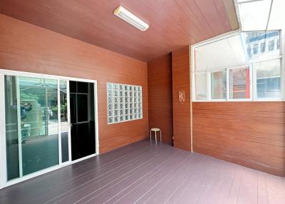 Spacious covered patio area with wooden paneling and sliding glass door