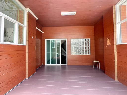 Spacious covered patio with tiled flooring and wooden walls