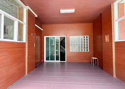 Spacious covered patio with tiled flooring and wooden walls