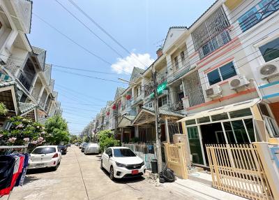 Sunny residential street scene with townhouses