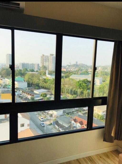 Bedroom with large window overlooking the city