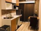 Compact modern kitchen with wood cabinets and stainless steel appliances