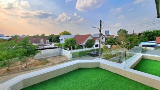 Spacious balcony with artificial grass overlooking a residential neighborhood