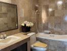 Spacious bathroom with marble tiles, a bathtub, and modern fixtures