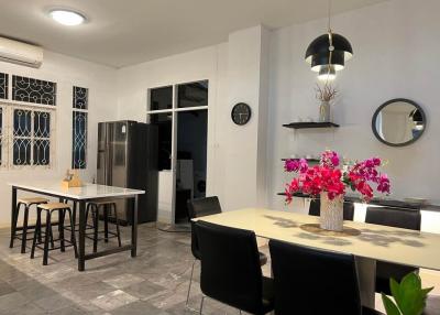 Modern kitchen with dining area featuring stainless steel refrigerator and tiled flooring