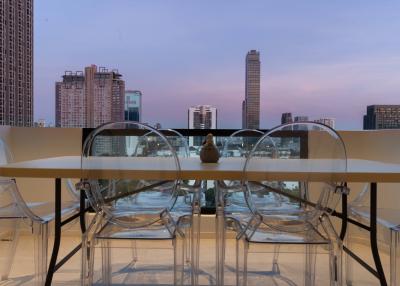 Modern balcony with city view and transparent chairs under the twilight sky