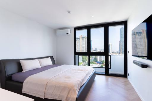 Modern bedroom with large windows and city view