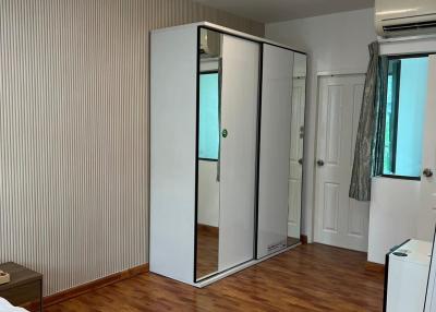 Spacious bedroom with wooden flooring and mirrored closet