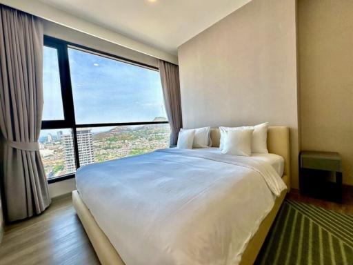 Modern bedroom with large window offering cityscape views