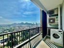 Spacious balcony with panoramic city and mountain view, air conditioning units, and laundry machine