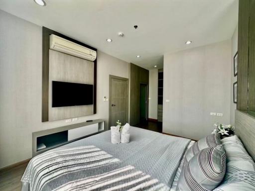 Modern bedroom with large bed and flat-screen TV