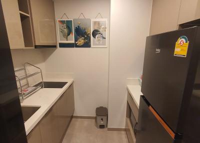 Modern and compact kitchen with fridge and wall art