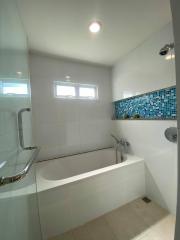 Modern bathroom with bathtub and blue mosaic tile detail