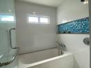 Modern bathroom with bathtub and blue mosaic tile detail