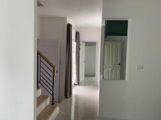 Bright hallway interior with staircase and doorways leading to different rooms