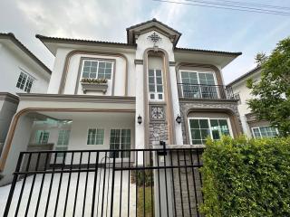 Elegant two-story house with stonework and iron fence