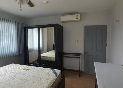 Spacious bedroom with large bed, mirror, and air conditioning unit