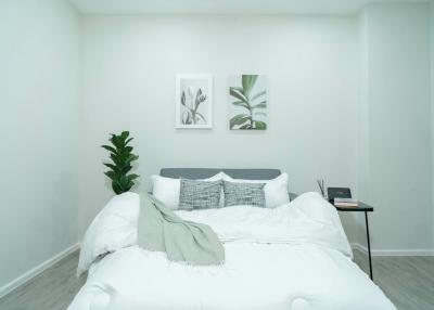 Cozy modern bedroom with white linens and wall art