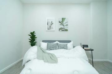 Cozy modern bedroom with white linens and wall art