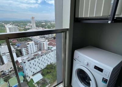 Compact laundry area with washing machine and city view