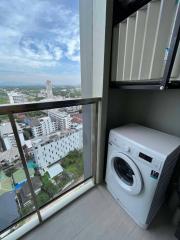 Compact laundry area with washing machine and city view