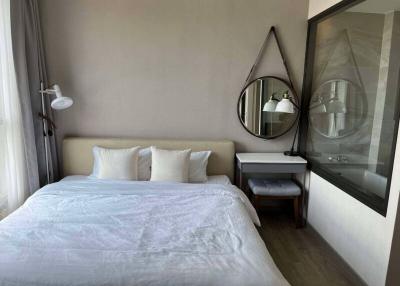 Modern bedroom with a comfortable double bed, wall-mounted lamps, and a large mirror