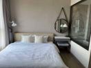 Modern bedroom with a comfortable double bed, wall-mounted lamps, and a large mirror