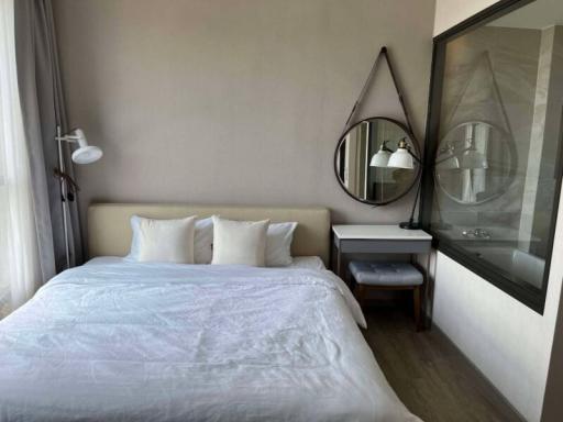 Modern bedroom with a comfortable double bed, wall-mounted lamps, and a large mirror