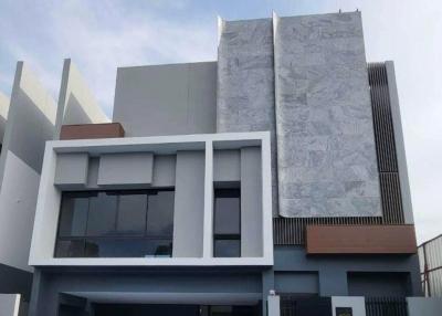 Modern two-story residential building facade with gray and white exterior finishes