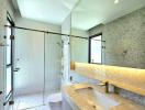 Modern bathroom interior with a shower cabin, large mirror and stone countertop