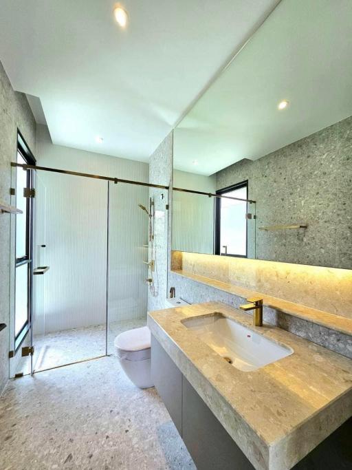 Modern bathroom interior with a shower cabin, large mirror and stone countertop