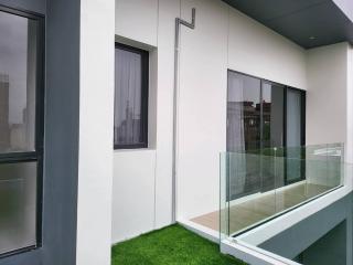 Modern balcony with glass railing and artificial grass