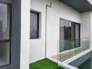 Modern balcony with glass railing and artificial grass