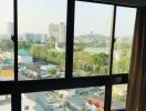 View from an upper-floor apartment overlooking the cityscape with large windows