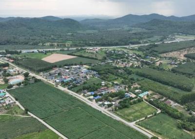 Aerial view of a rural landscape with community, fields, and mountains