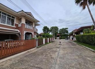 Residential street with a view of a two-story house and fenced properties