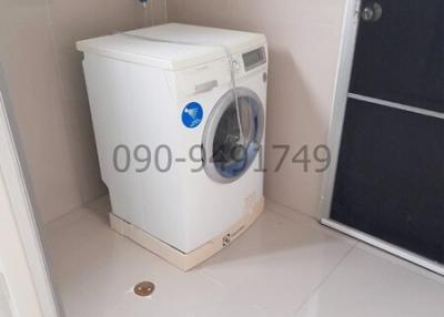 Compact laundry room with a white washing machine