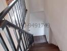 Modern staircase in a residential property with dark wood steps and metal railings